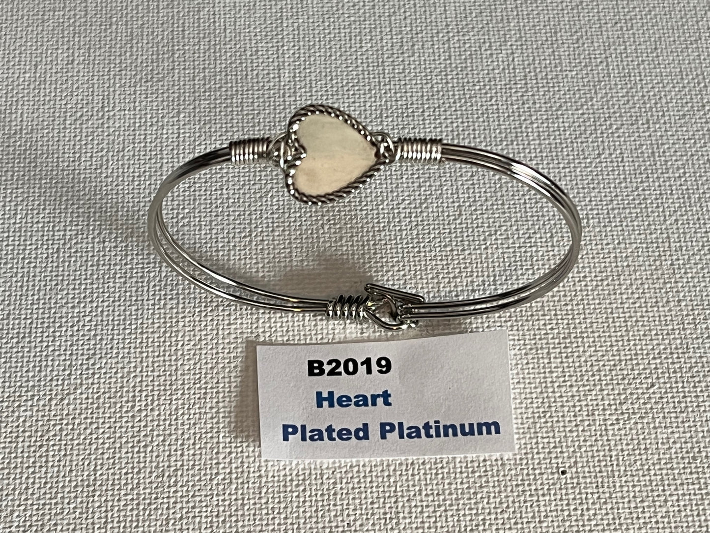 Oval Wired Bracelets with Charm (Various Style) Styles Include: 22k Gold Plated Heart 22k Gold Plated Butterfly 22k Gold Plated Dog Heart Platinum-Plated Butterfly Platinum-Plated Dog Platinum-Plated 22k Gold Plated Cowgirl Hat 22k Gold Plated Cat Cowgirl Hat Platinum-Plated Cat Platinum-Plated